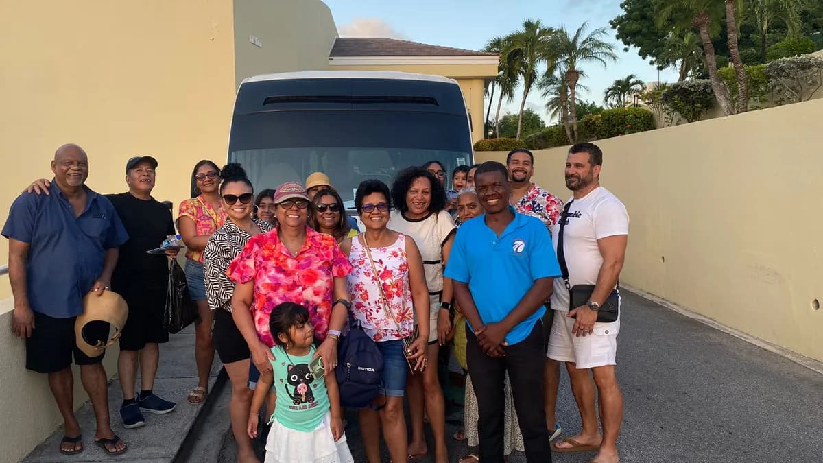 Family group with guide in front of tour bus