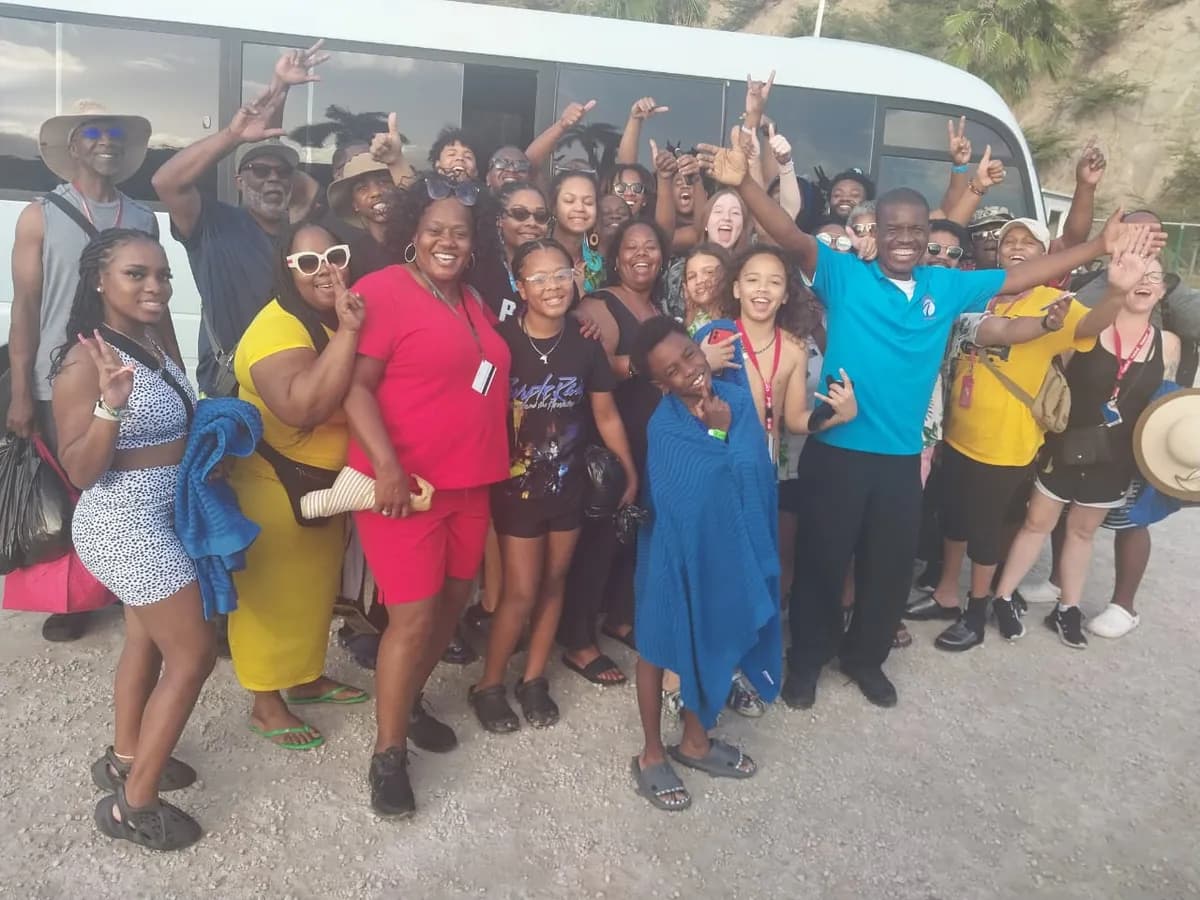 Happy tour group posing with guide and Confidence Tours bus